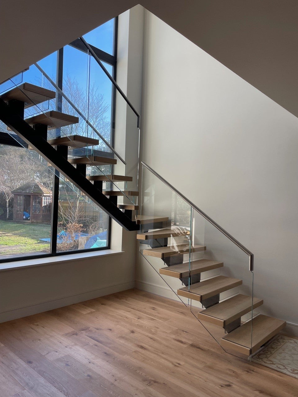 InvisiFix spine staircase with oak treads and frameless glass, hidden fixings