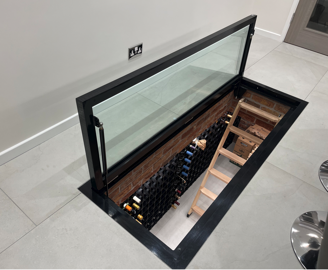 Hinged glass trap door hatch with a flush streamline handle