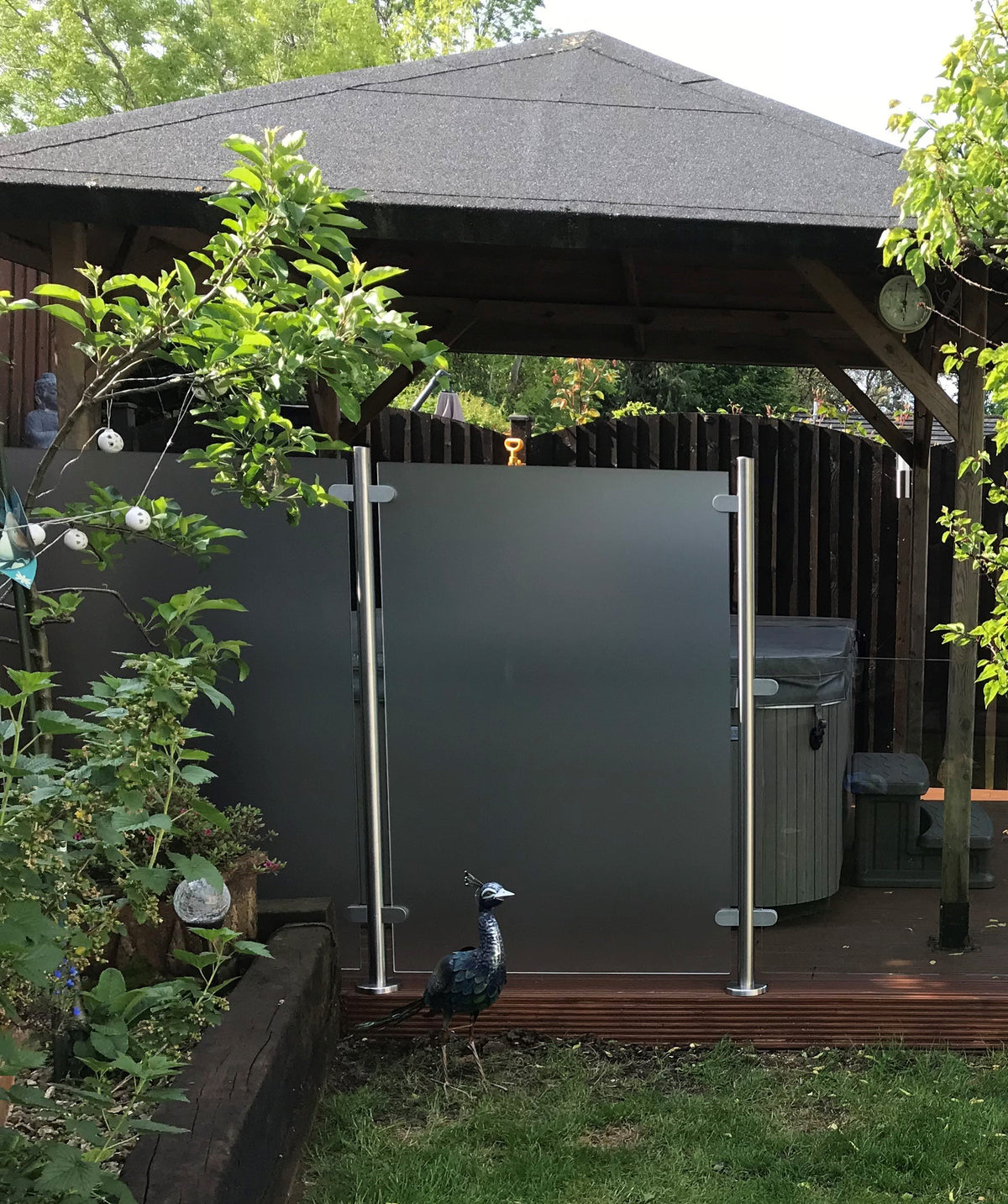 Glass privacy screen sheltering a hot tub area
