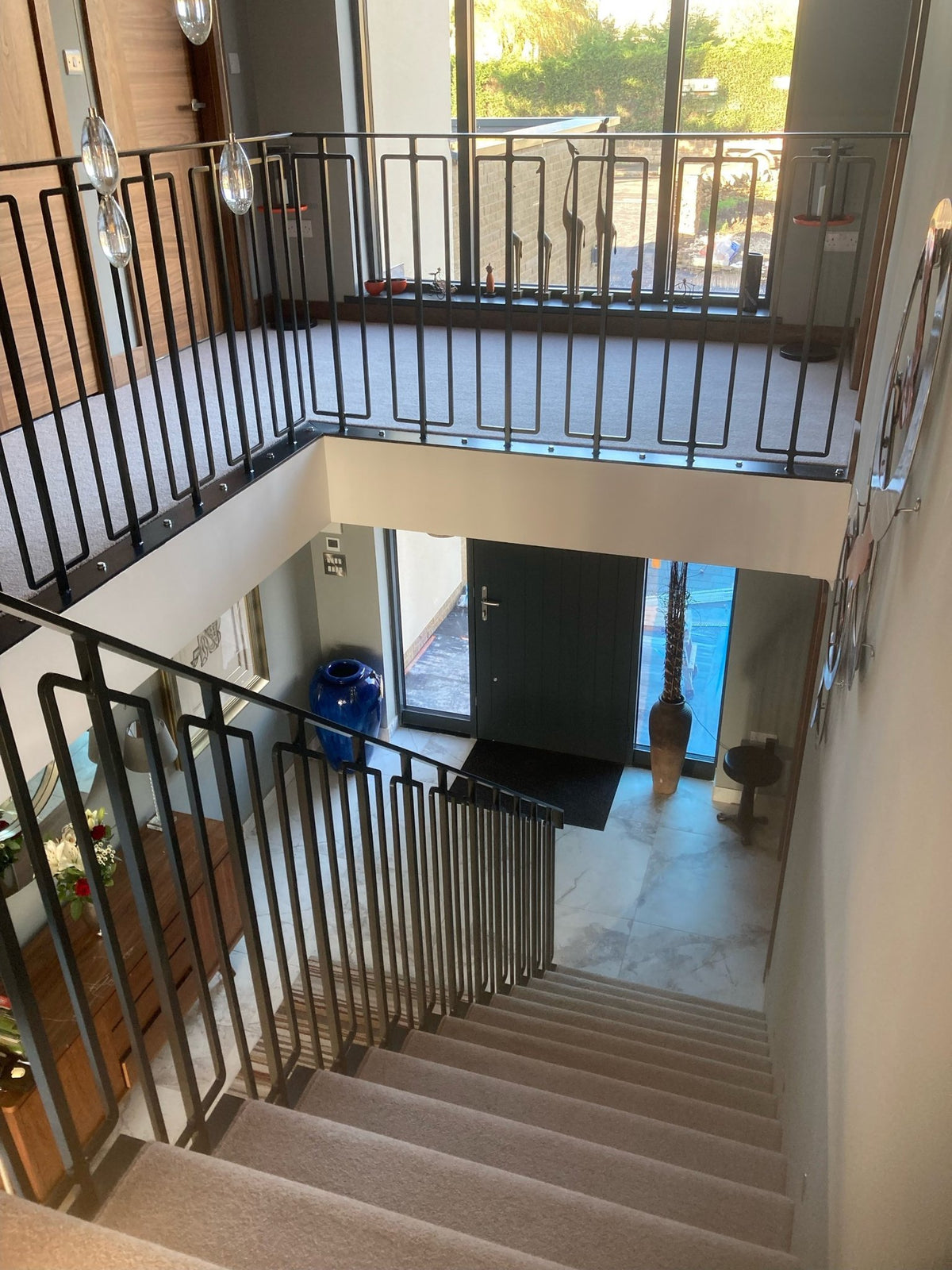 Internal metal balustrade to a galleried landing with rectangular loop balusters, over a steel staircase