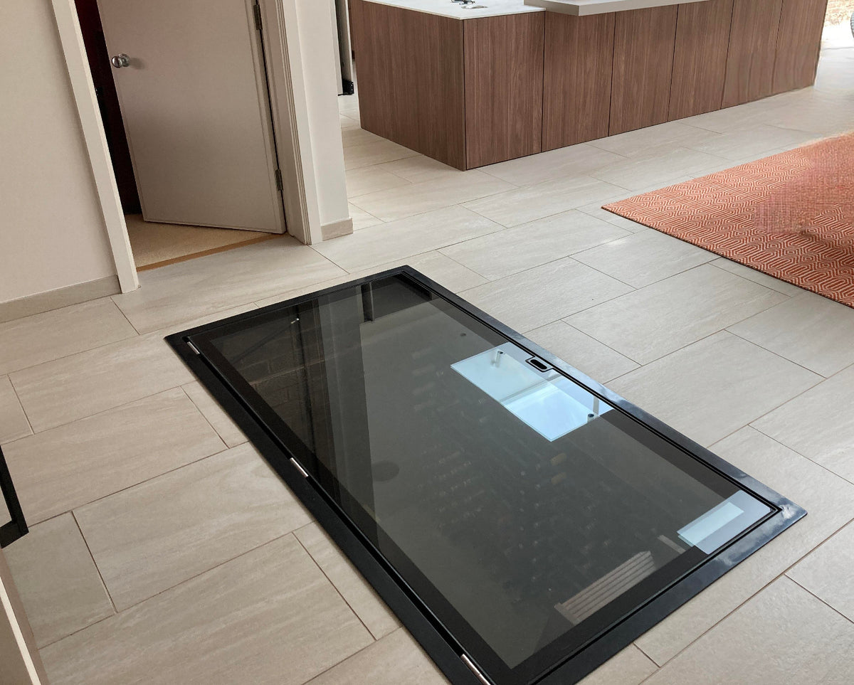 Large glass wine cellar door set into a floor