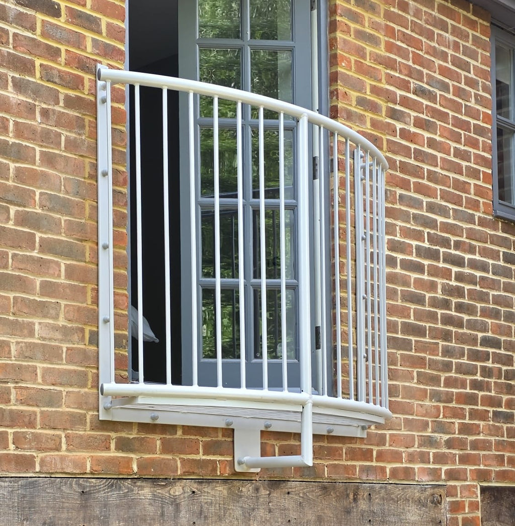 Lincoln curved Juliet balcony in white, showing the bow of the curve and the support bracket