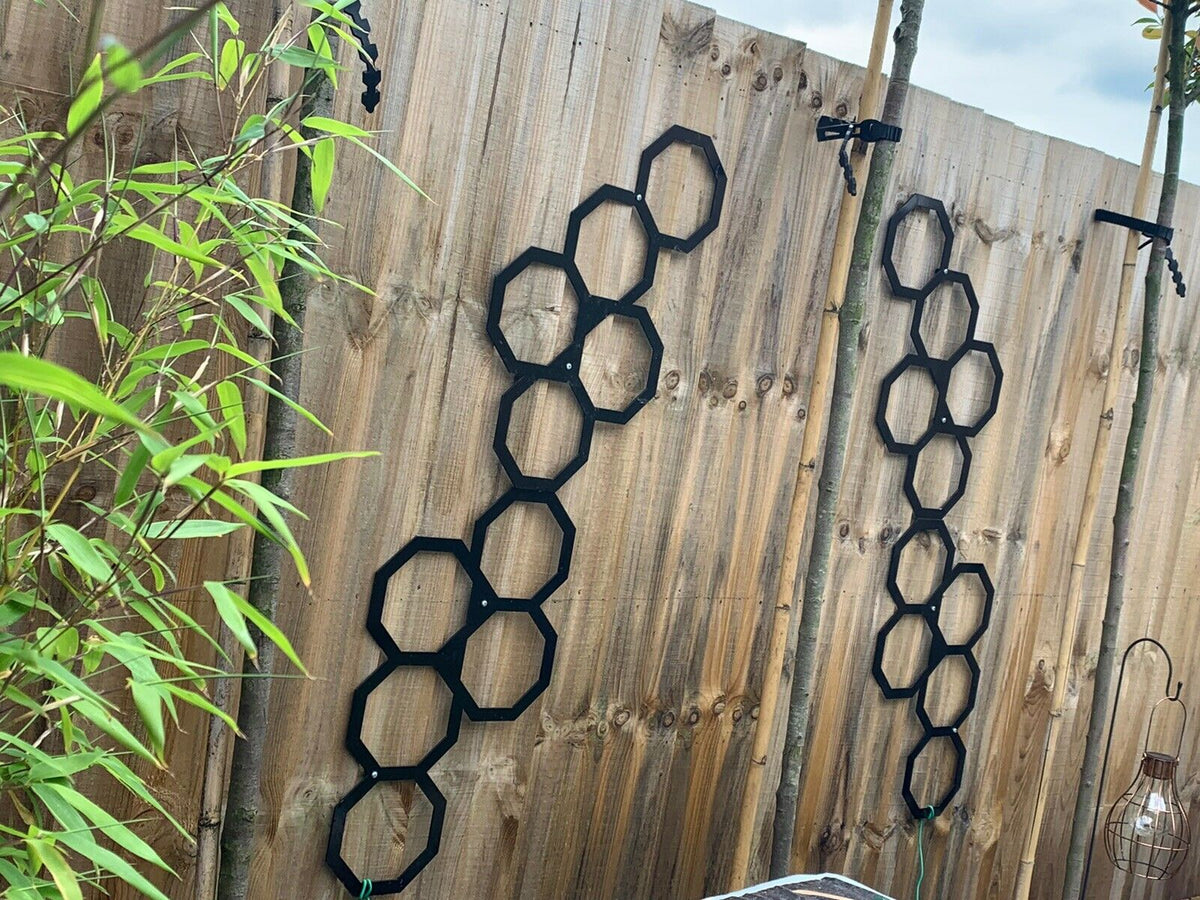 Black powder coated metal trellis panels on a garden wall