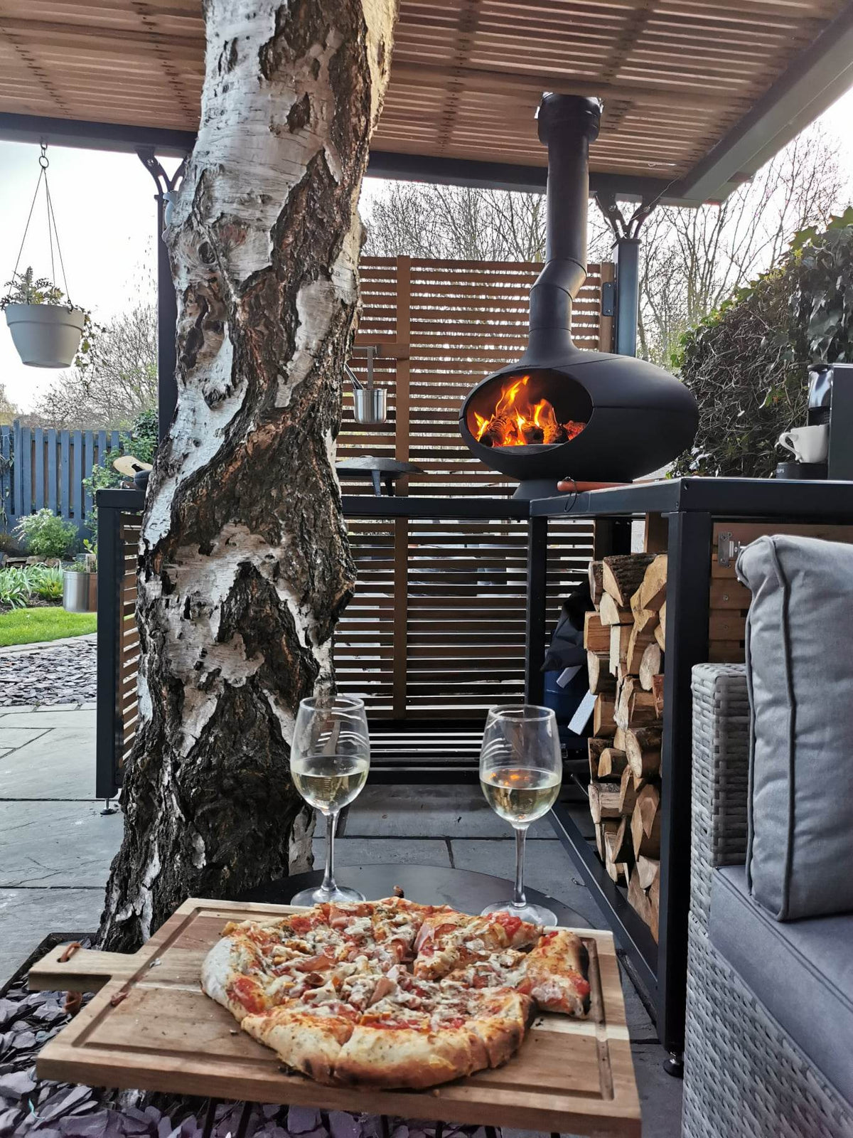 Modern steel pergola with a wood burner underneath