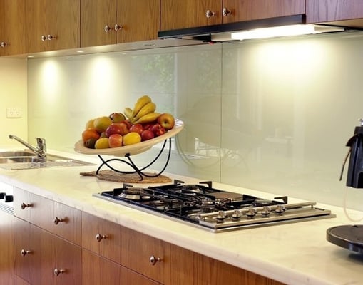 Cream backpainted glass splashback along a kitchen worktop and hob