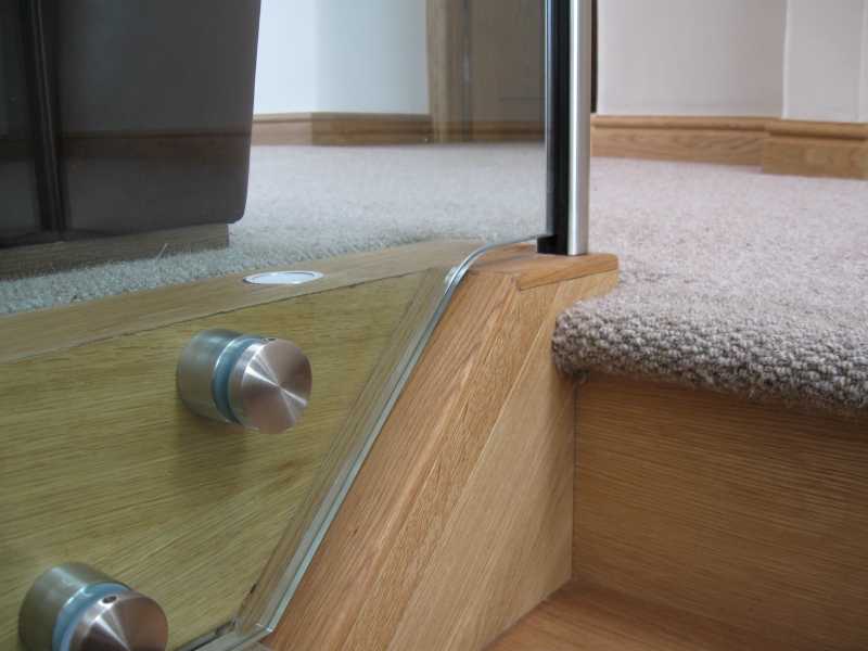 Row of side fixing adapters lined up along a balcony edge before glazing