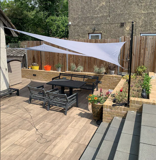 Shade sail rigged on steel poles over a patio