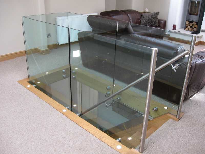 Slotted stainless steel handrail capping a frameless glass balustrade