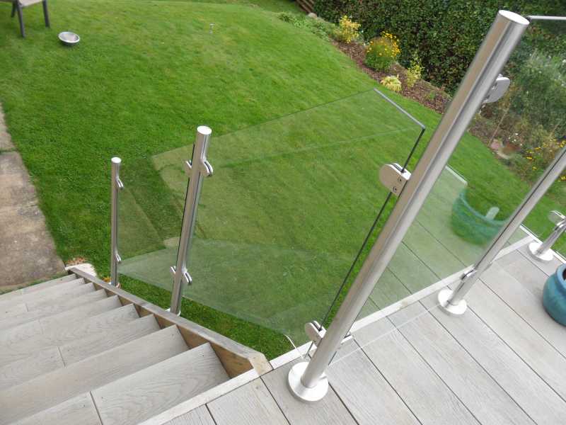 Stainless steel baluster posts base fixed to a finished deck surface