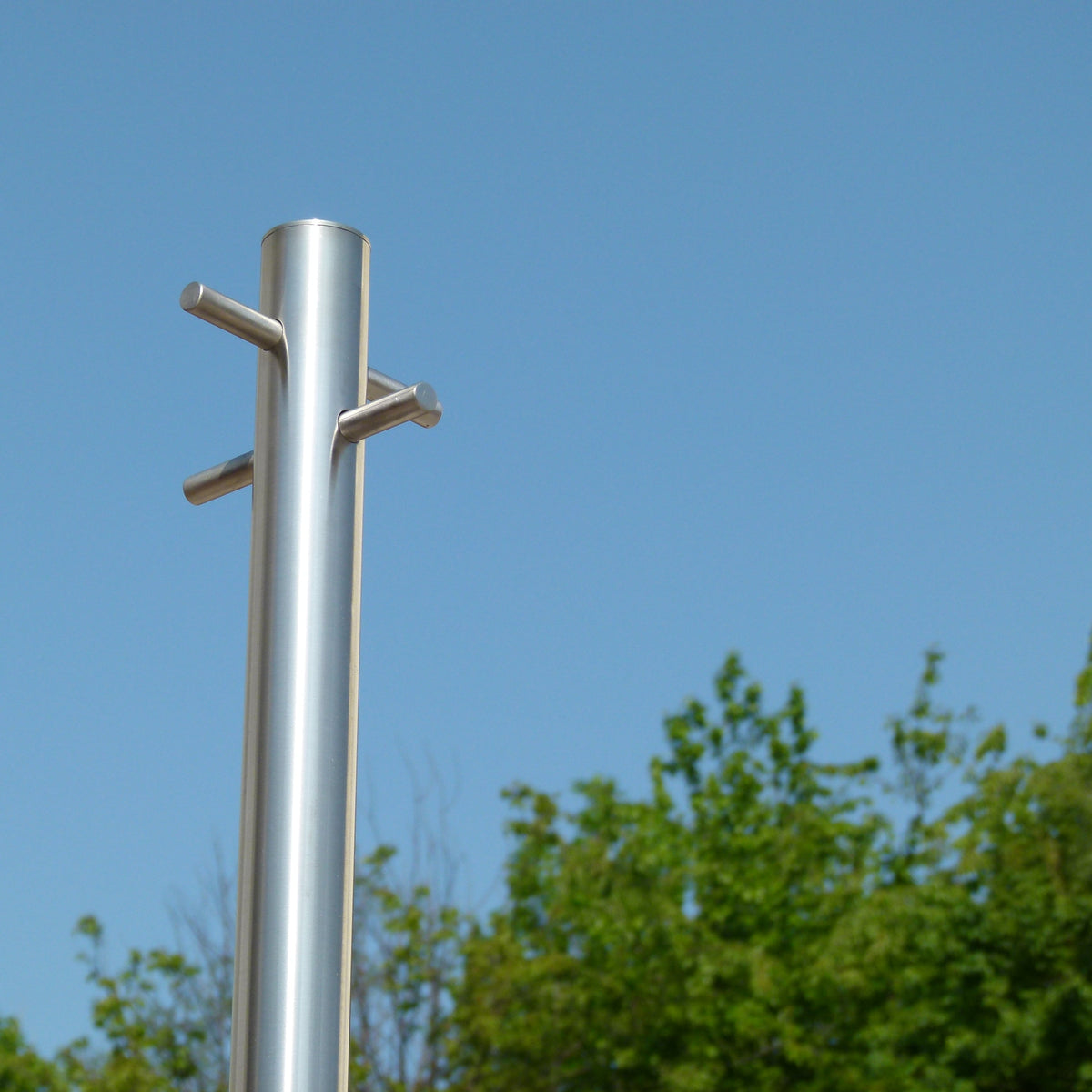 Stainless steel washing line pole against a blue sky showing the brushed finish and tie-bars