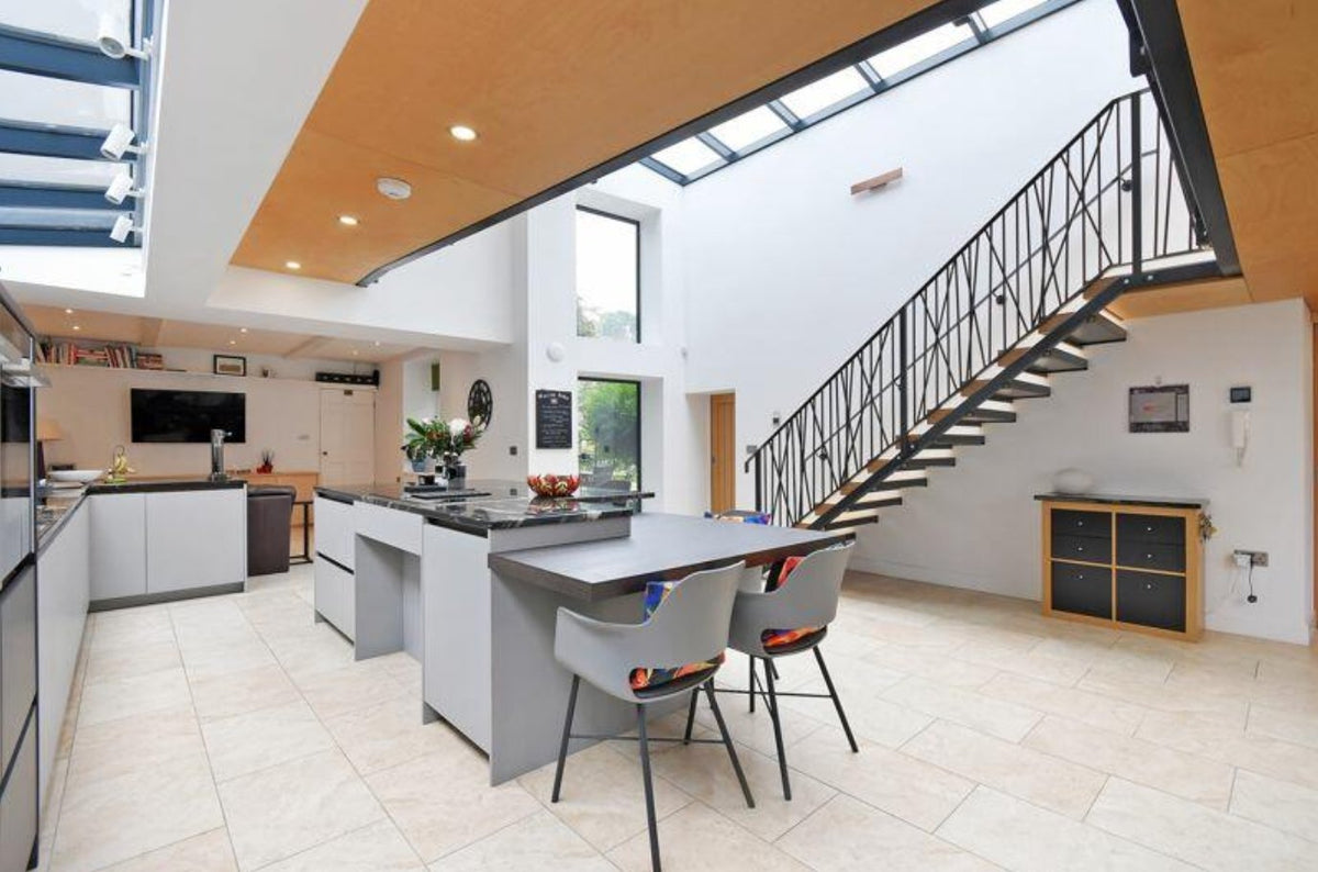 Steel staircase with timber treads and a bespoke angled bar infill balustrade in an open plan kitchen