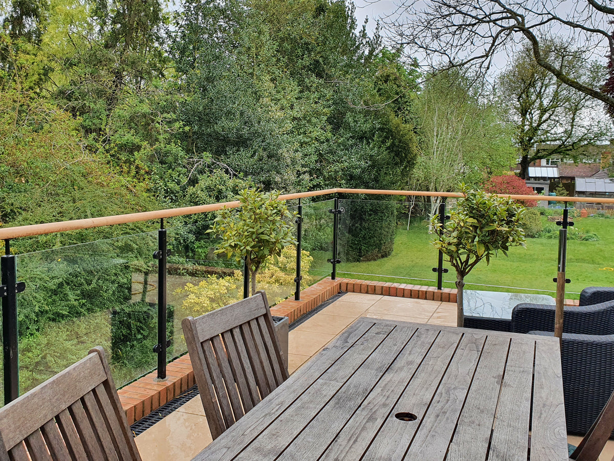 Powder coated steel and glass balustrade with a timber top rail