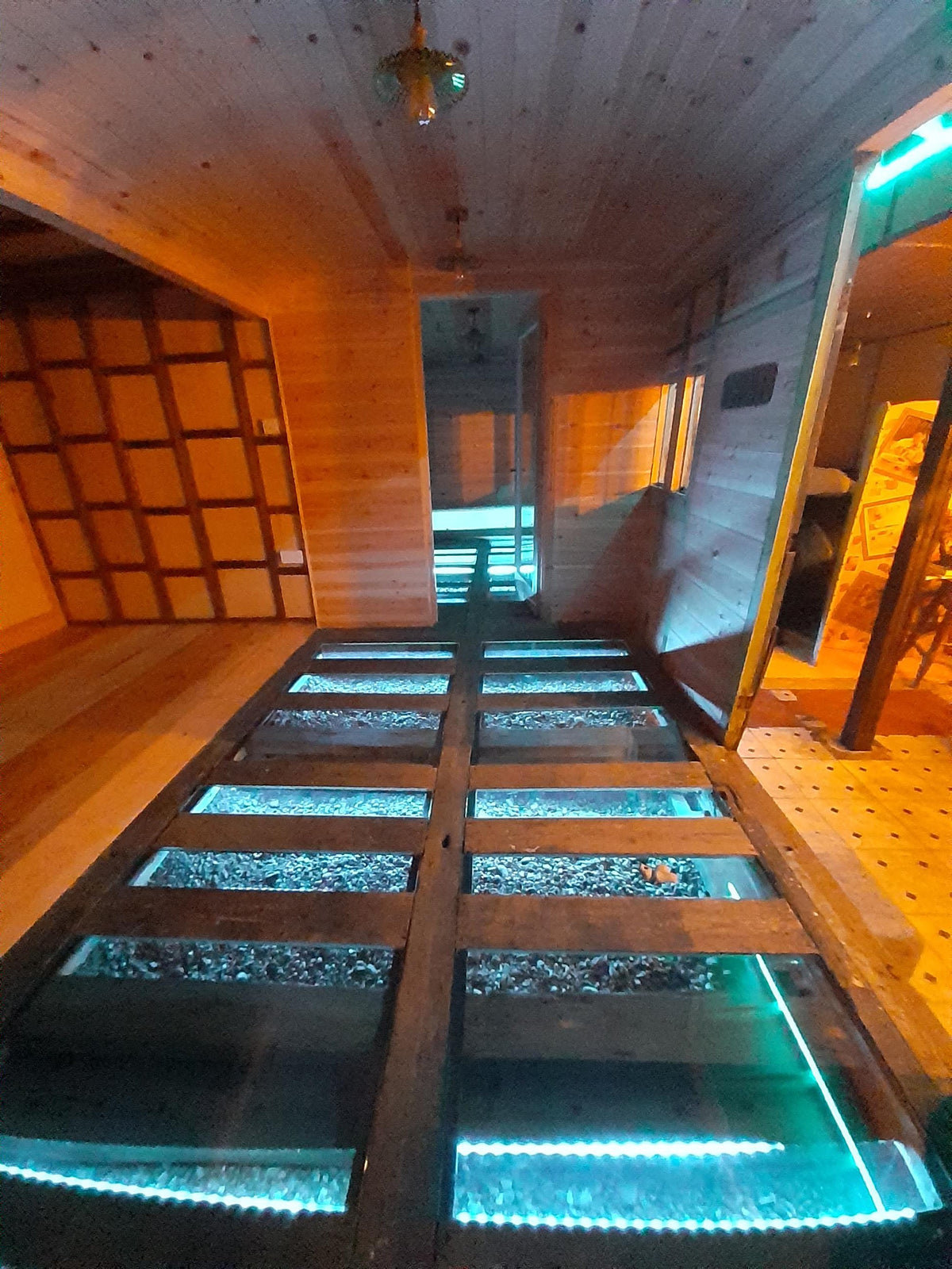 31.5mm walk-on laminated floor glass panels with LED lighting in a timber lined room