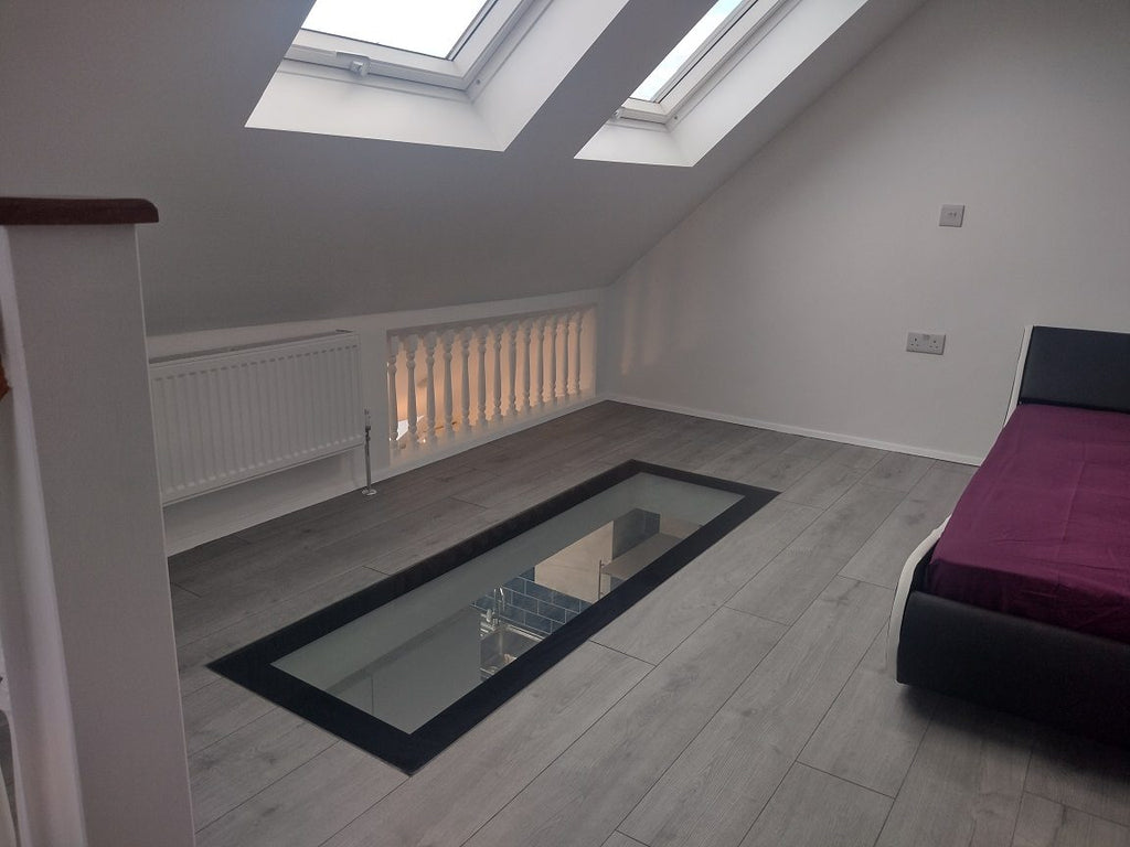 Narrow walk-on glass floor strip in a steel frame set into a loft bedroom floor