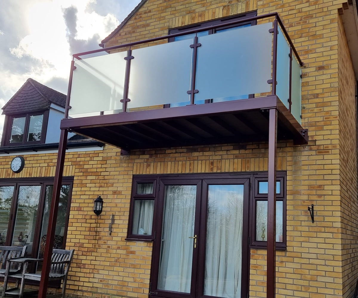 Walk-out balcony with a powder coated brown steel balustrade and framed glass panels, Cambridge