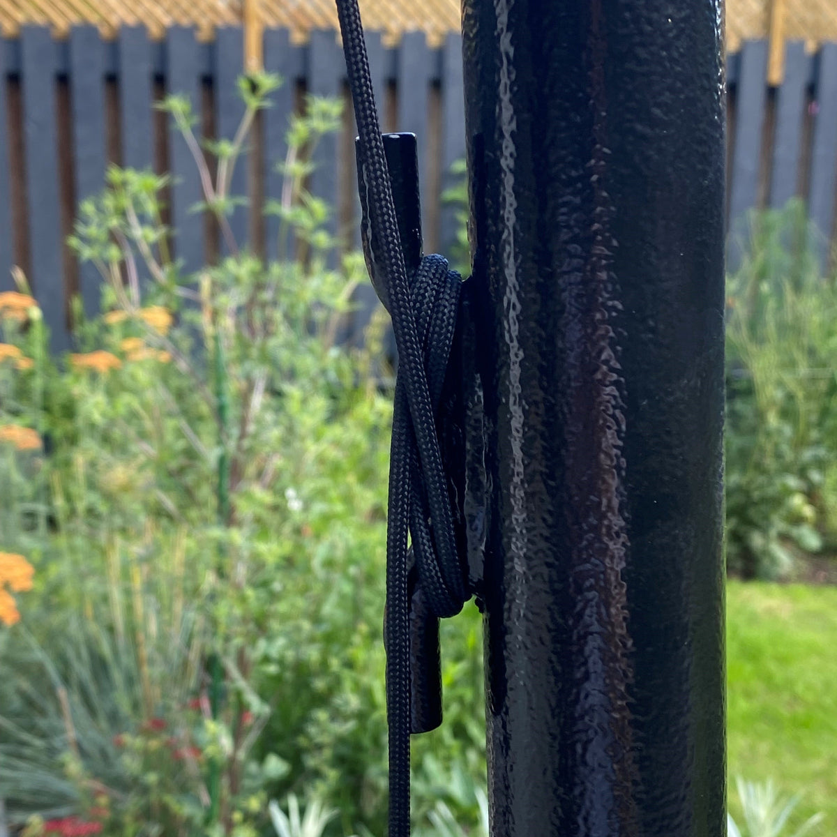 Washing line tied off around the welded cleat on a black loop and cleat pole