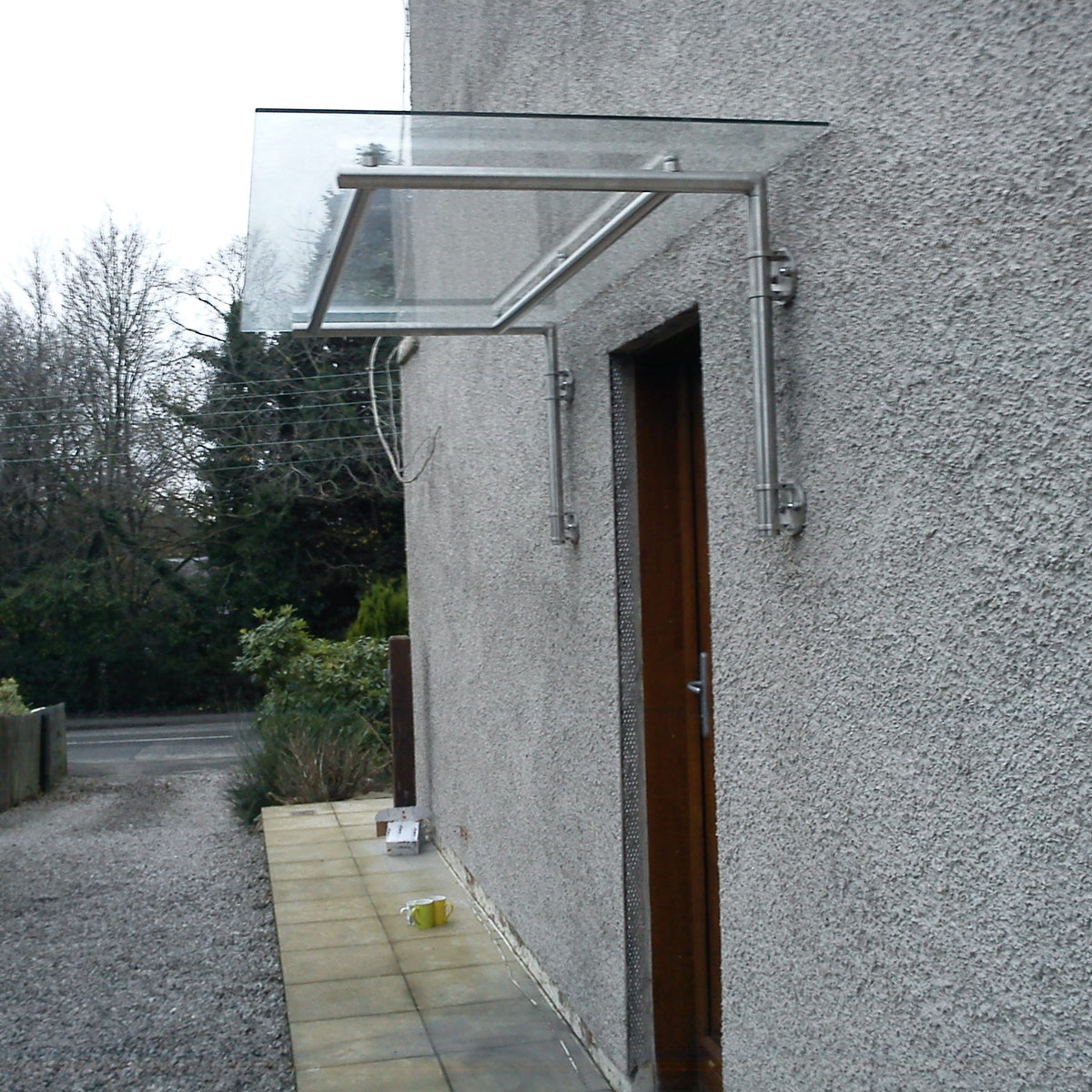 Wide span glass canopy showing the stainless steel bracket and glass clamp