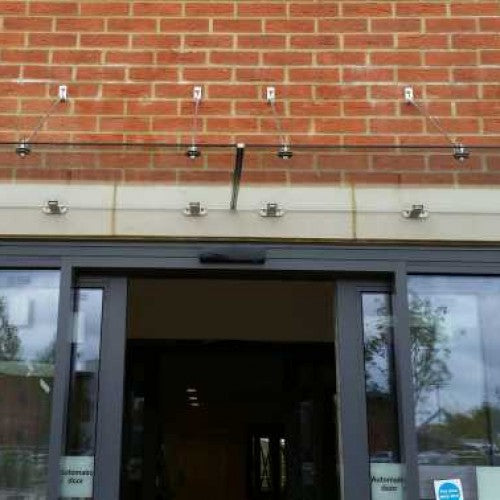 Wide suspended glass canopy over a front door