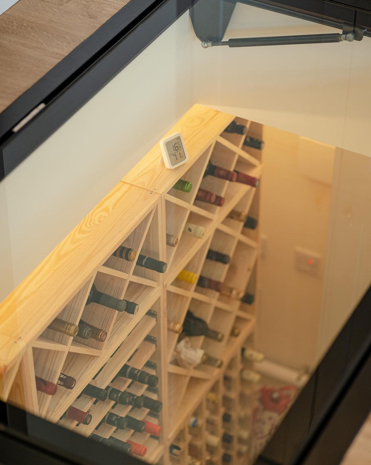 Glass hatch forming the entrance to a wine cellar