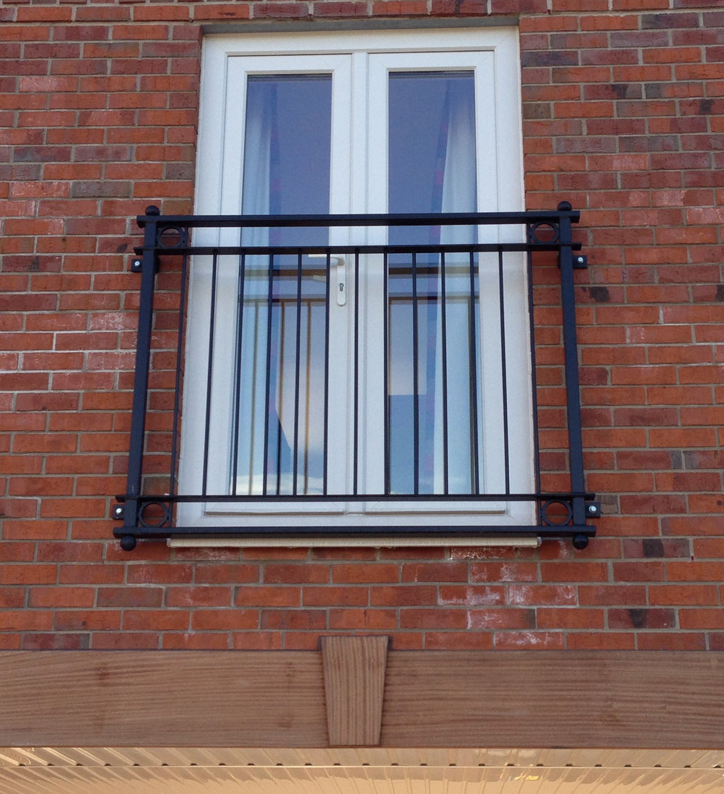 York galvanised steel Juliet balcony powder coated black, fitted to French doors on a red brick house